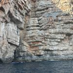 Blue Cave by Good Hope Tours, with rocks and sea in front of the entrance