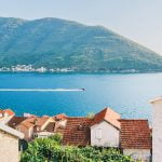 Scenic view of Perast, showcasing historic buildings and the coastline, with a view of the sea from the town